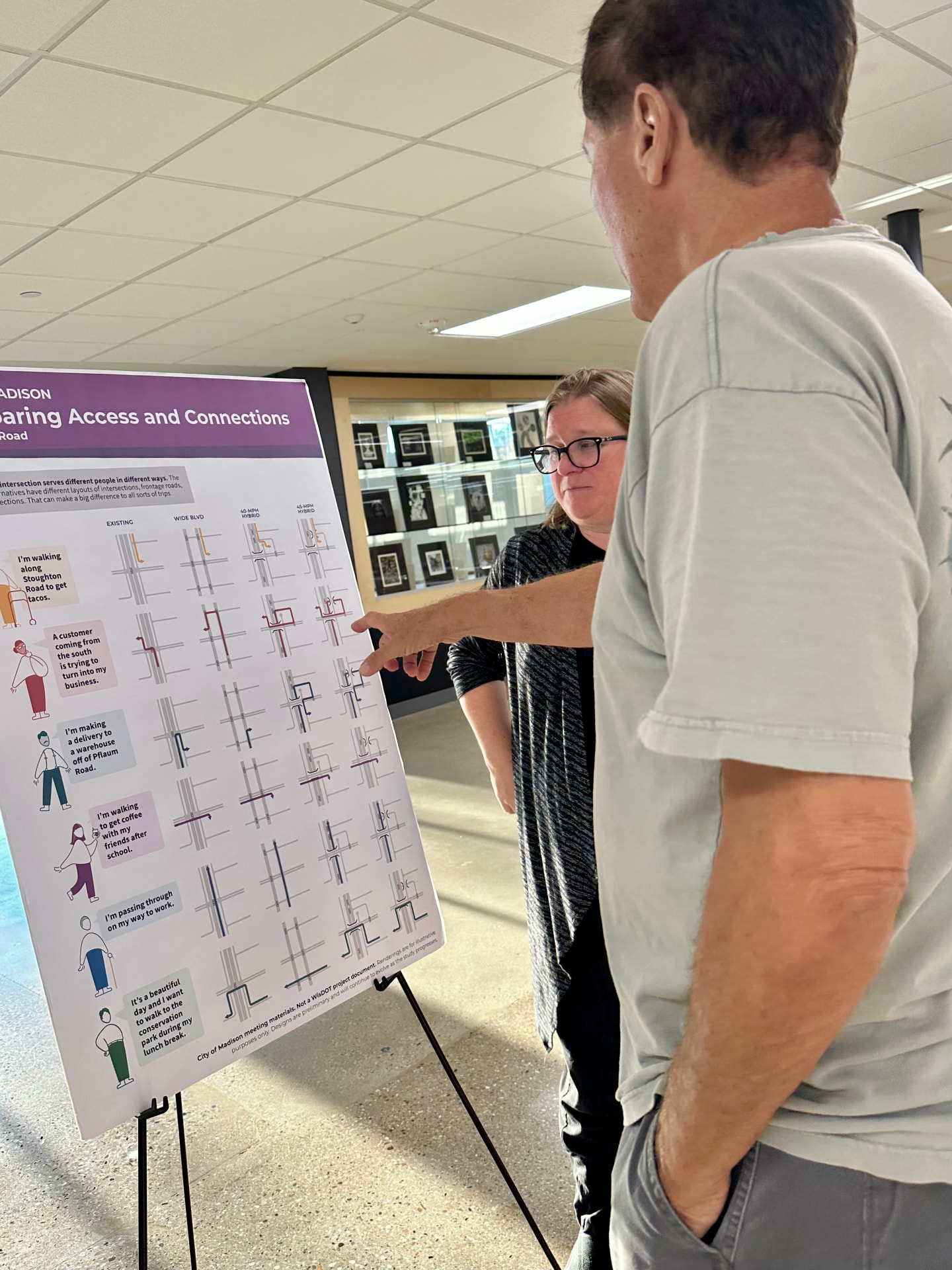 A resident points at the Comparing Access and Connections display board