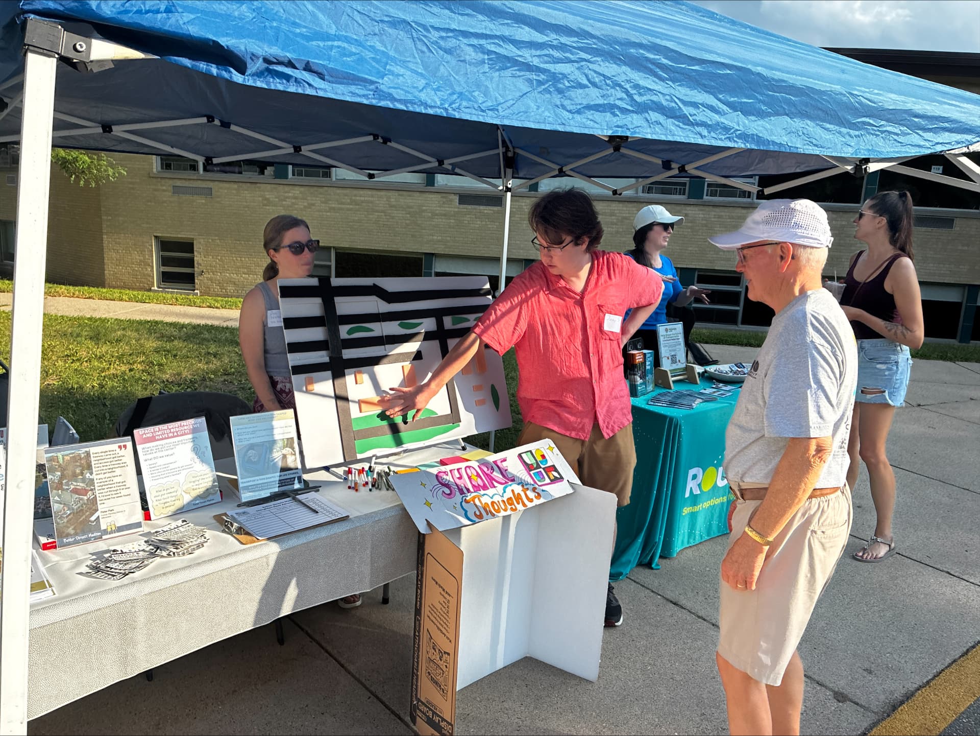 A volunteer explaining the corridor model to a festival attendee